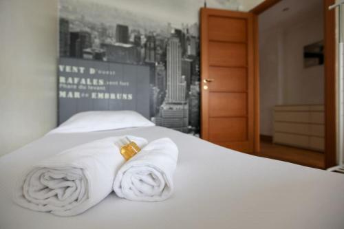 a bed with white towels on it with a city skyline at FieraMilano 3BR Apartment in Milan