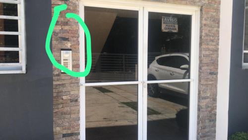 a door with a green sign on the side of a building at Paramount 3-Bedroom Apartment with Parking in San Felipe de Puerto Plata
