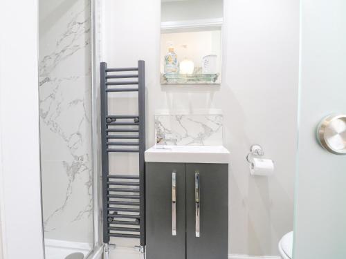 un baño con lavabo y ducha en Matlock Maisonette, en Matlock