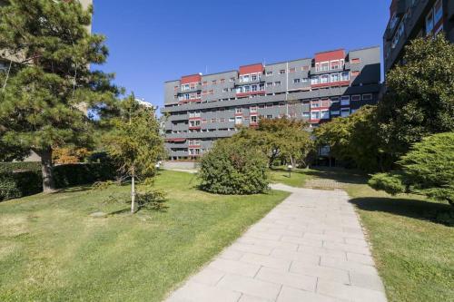 a building with a walkway in front of a park at FieraMilano 3BR Apartment in Milan