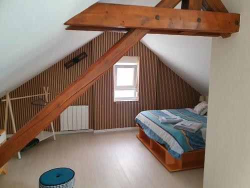 1 dormitorio en el ático con cama y ventana en Appartement cosy proche centre, en Colmar