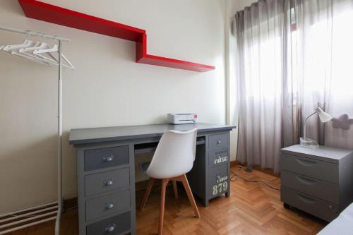 a desk with a white chair in a bedroom at FieraMilano 3BR Apartment in Milan