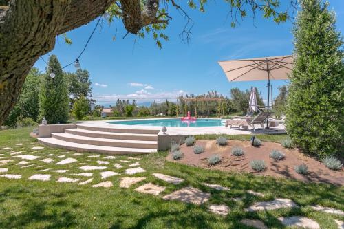 a backyard with a swimming pool and a tree at La Betulla - Ocean-Mountain View LUX in Montone