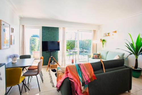a living room with a couch and a table at A13 - 1 BDR Garden floor Fontonne - AC, Pool & Parking in Antibes