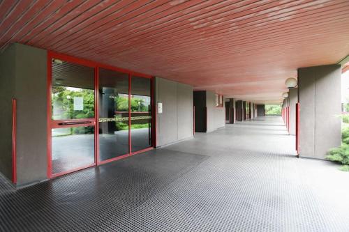 an empty hallway of a building with a red ceiling at FieraMilano 3BR Apartment in Milan