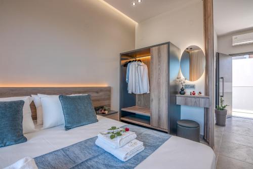 1 dormitorio con cama blanca y espejo en Litinakis Studios, en Agia Marina de Nea Kydonia