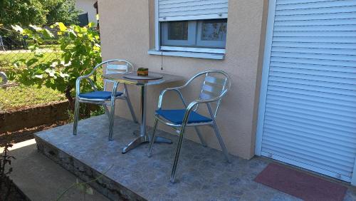two chairs and a table on a patio at Airport apartment T&T in Surčin