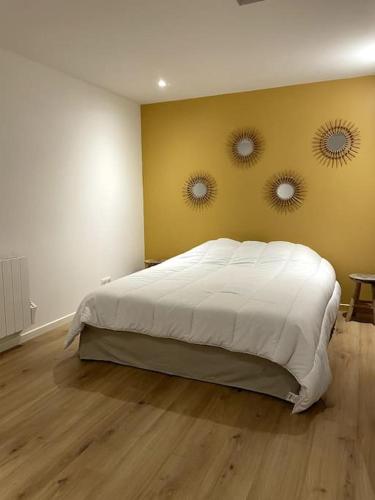 a bedroom with a bed with two mirrors on the wall at Appartement en hyper centre in Étaples
