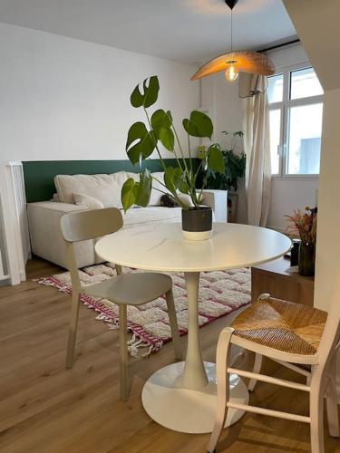 un salon avec une table et une plante en pot dans l'établissement Appartement en hyper centre, à Étaples