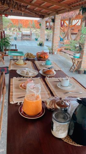 a long table with plates of food and drinks on it at Pousada rancho sol nascente in Tutóia