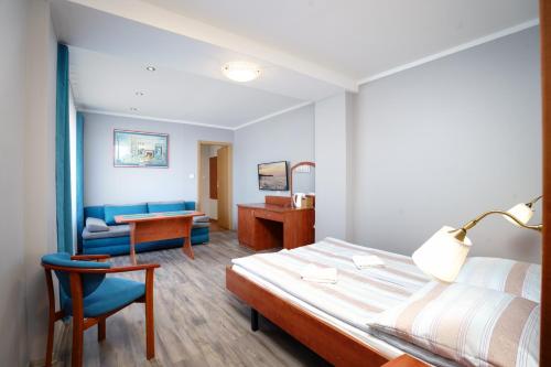 a bedroom with a bed and a desk and a chair at Willa Karawela in Łeba