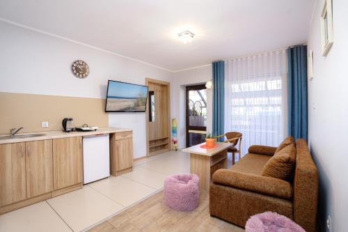 a living room with a couch and a kitchen at Willa Karawela in Łeba