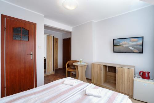 a bedroom with a bed and a wooden door at Willa Karawela in Łeba