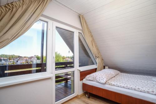 a small room with a bed and a window at Willa Karawela in Łeba