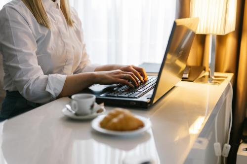 a woman sitting at a desk with a laptop computer at Hotel Heritage in Belgrade