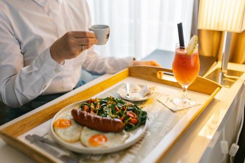 a tray with a plate of food and a drink at Hotel Heritage in Belgrade