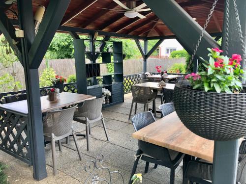 an outdoor patio with tables and chairs and flowers at Katalin Motel & Étterem in Berettyóújfalu