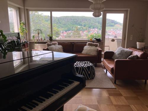 a living room with a piano and a couch at Großzügige Wohnung mit Flair und Aussicht in Bad Bergzabern