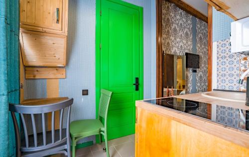 una puerta verde en una cocina con mesa y sillas en Apart View Hotel & Spa en Tiflis