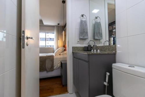 ein kleines Bad mit einem Waschbecken und einem WC in der Unterkunft Incrível Studio 308 - Batel CWB (melhor localização) in Curitiba