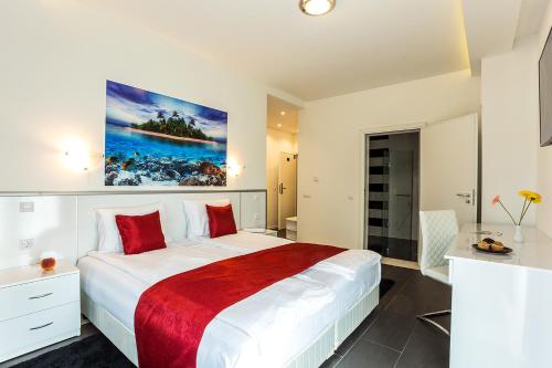 a bedroom with a large white bed with a red blanket at Complex Europe in Dolna Banya