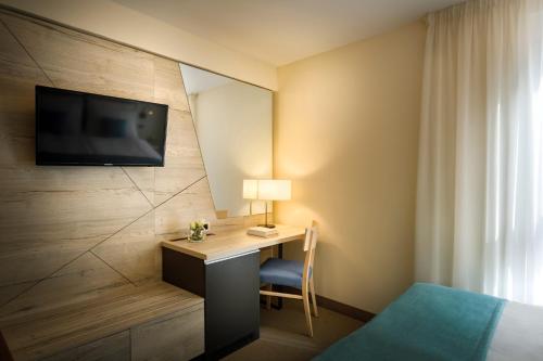 a hotel room with a desk and a tv on a wall at Hotel Marina - Liburnia in Mošćenička Draga