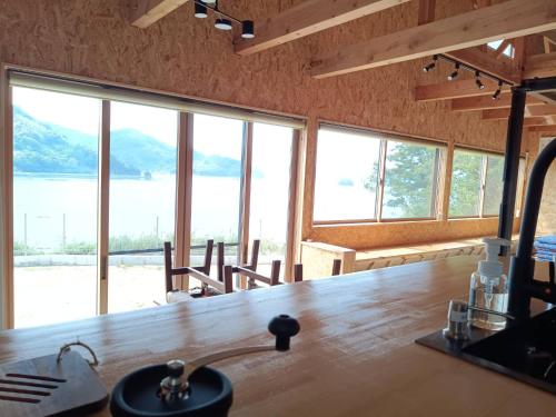 a room with a large wooden table with a large window at nagi-setouchi in Kure
