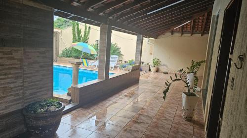 a patio with a swimming pool and an umbrella at Area de lazer Lua e Sol in Franca