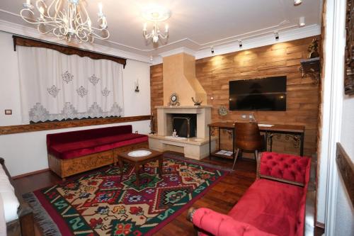 a living room with a red couch and a fireplace at City Street Hotel in Gjirokastër