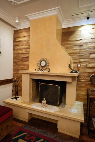 a living room with a fireplace with a clock at City Street Hotel in Gjirokastër