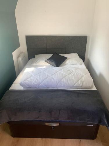 - un lit avec des draps blancs et un oreiller dans l'établissement Appartement avec balcon plein sud, bord de mer, à Saint-Aubin-sur-Mer