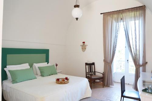a bedroom with a bed and a chair and a window at Villa Puolo - With Private Sea Access in Sorrento
