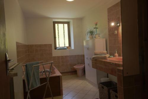 une salle de bain avec un lavabo et un réfrigérateur dans l'établissement Maison du Tertre, à Urval