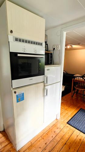 a kitchen with a white stove and a microwave at Ystad Holiday Houses in Ystad