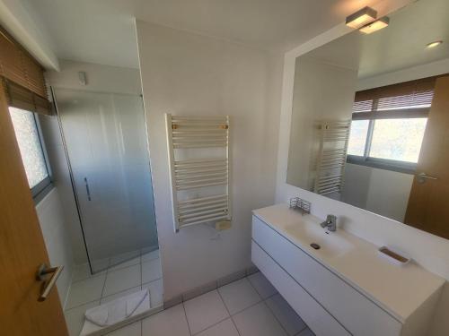 une salle de bain blanche avec un lavabo et une douche dans l'établissement White Pearl, à Antibes