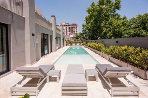 a swimming pool with chaise lounge chairs next to a building at Premium Apt 2BR 24x7 San Telmo 300 Mb La Galerie in Buenos Aires