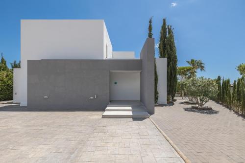 a white building with a door in a courtyard at Villa Marc II in Sant Jordi