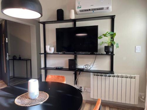 a dining room with a table and a tv at Premium Apt 2BR 24x7 San Telmo 300 Mb La Galerie in Buenos Aires