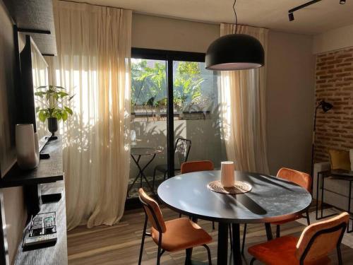a living room with a table and chairs and a kitchen at Premium Apt 2BR 24x7 San Telmo 300 Mb La Galerie in Buenos Aires