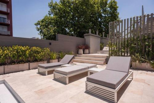a patio with two chairs and a bench at Premium Apt 2BR 24x7 San Telmo 300 Mb La Galerie in Buenos Aires