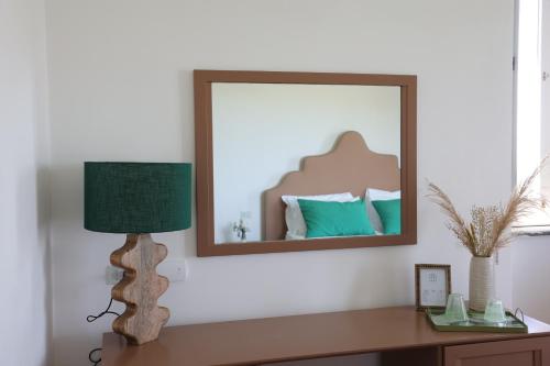 uno specchio su un muro sopra una scrivania con lampada di Villa Puolo - With Private Sea Access a Sorrento