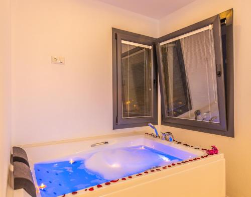 a blue tub in a bathroom with two windows at Albedo Villa in Kas