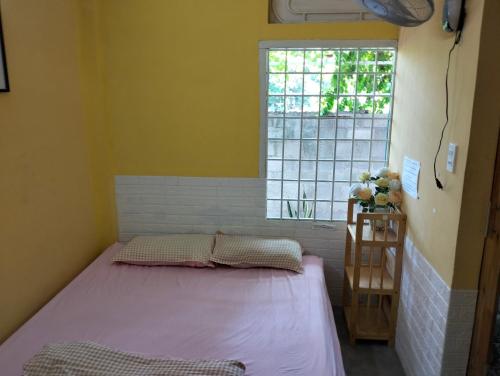 a small room with a bed and a window at BONNIE HOMESTAY Mui Ne in Mui Ne