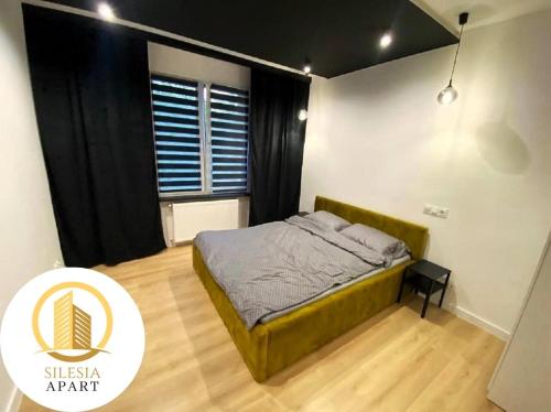 a bedroom with a bed and a large window at Apartament Zielony in Tychy