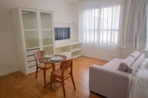 a living room with a table and a couch at Blend Coliving One - 1 in Ribeirão Preto