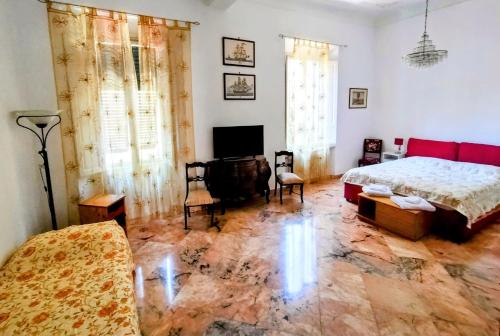 1 dormitorio con cama, sofá y TV en GABRY'S Cozy 3-bedroom big apartment near city center & station en Livorno