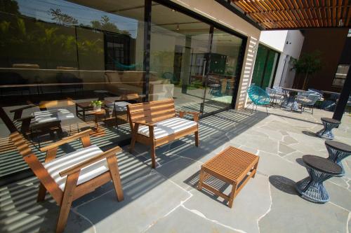 a patio with benches and tables and chairs at Blend Coliving One - 1 in Ribeirão Preto