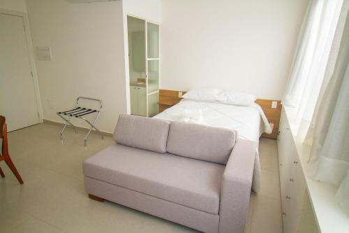 a bedroom with a couch and a bed and a chair at Blend Coliving One - 1 in Ribeirão Preto