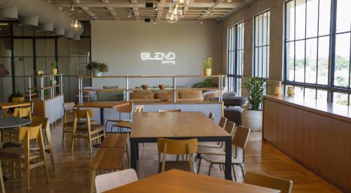a restaurant with tables and chairs and windows at Blend Coliving One - 1 in Ribeirão Preto