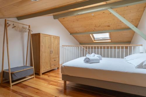 une chambre avec un lit et un plafond en bois dans l'établissement La Thibaudière - Appt en centre-ville, à Arcachon